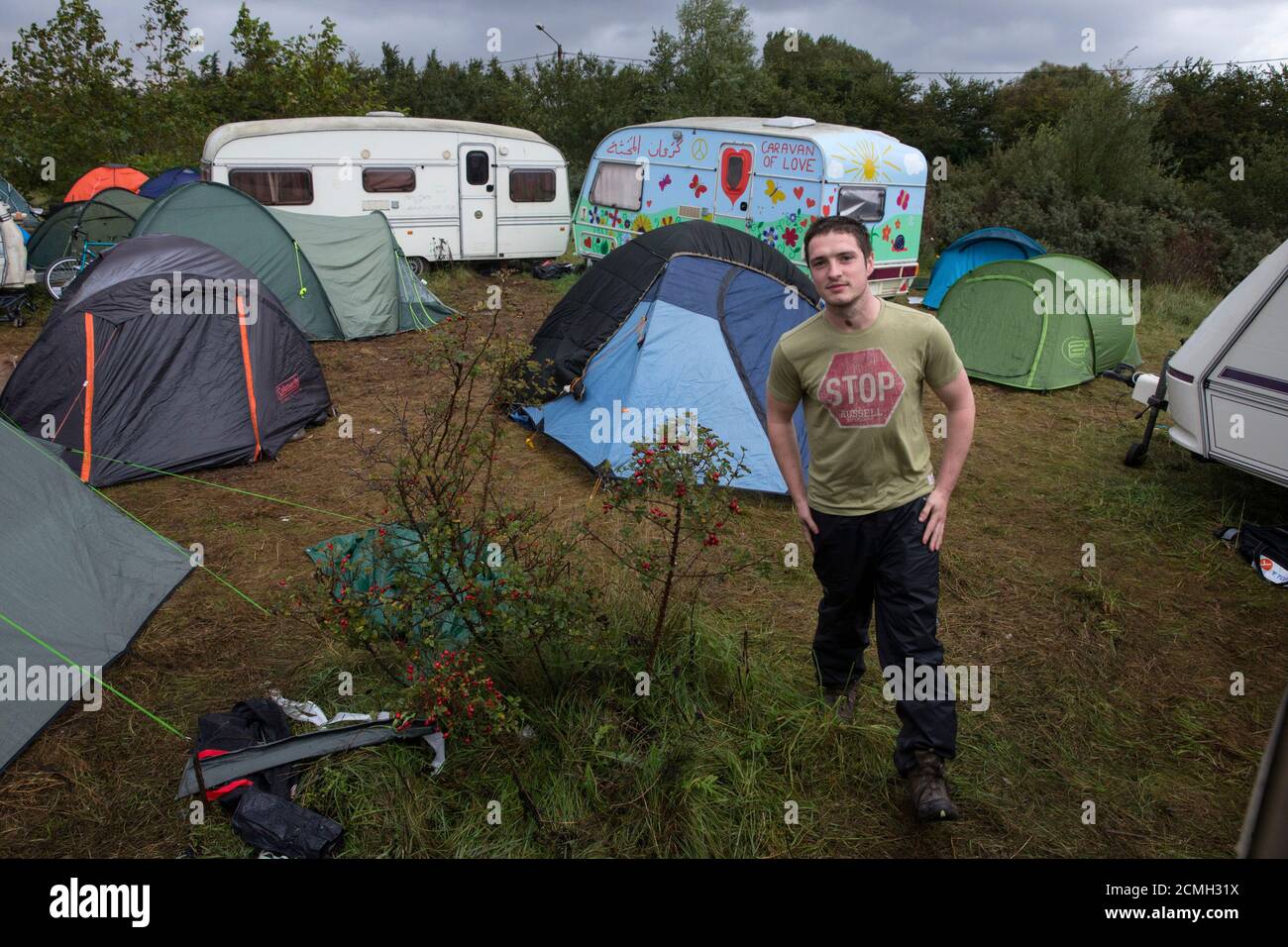 British volunteer Ed Cotton walks in the "New Jungle" makeshift camp as  unseasonably cool temperatures arrive in Calais, northern France, October  16, 2015. Cotton, a Human Rights Law graduate, arrived in Calais