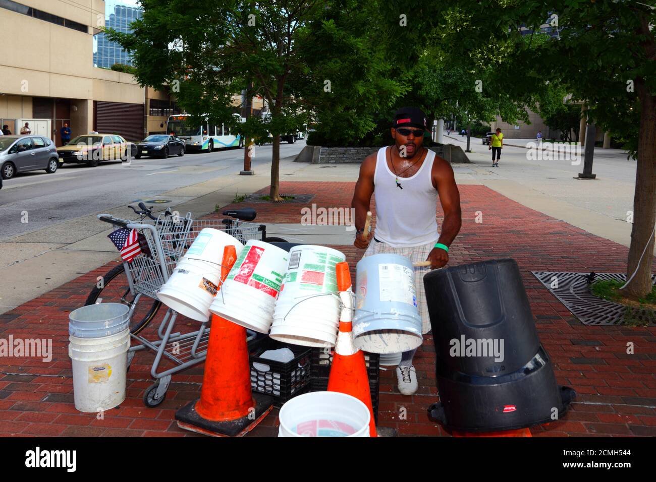 African American man playing homemade drum kit made from plastic buckets and bins in street, Baltimore, Maryland, USA Stock Photo