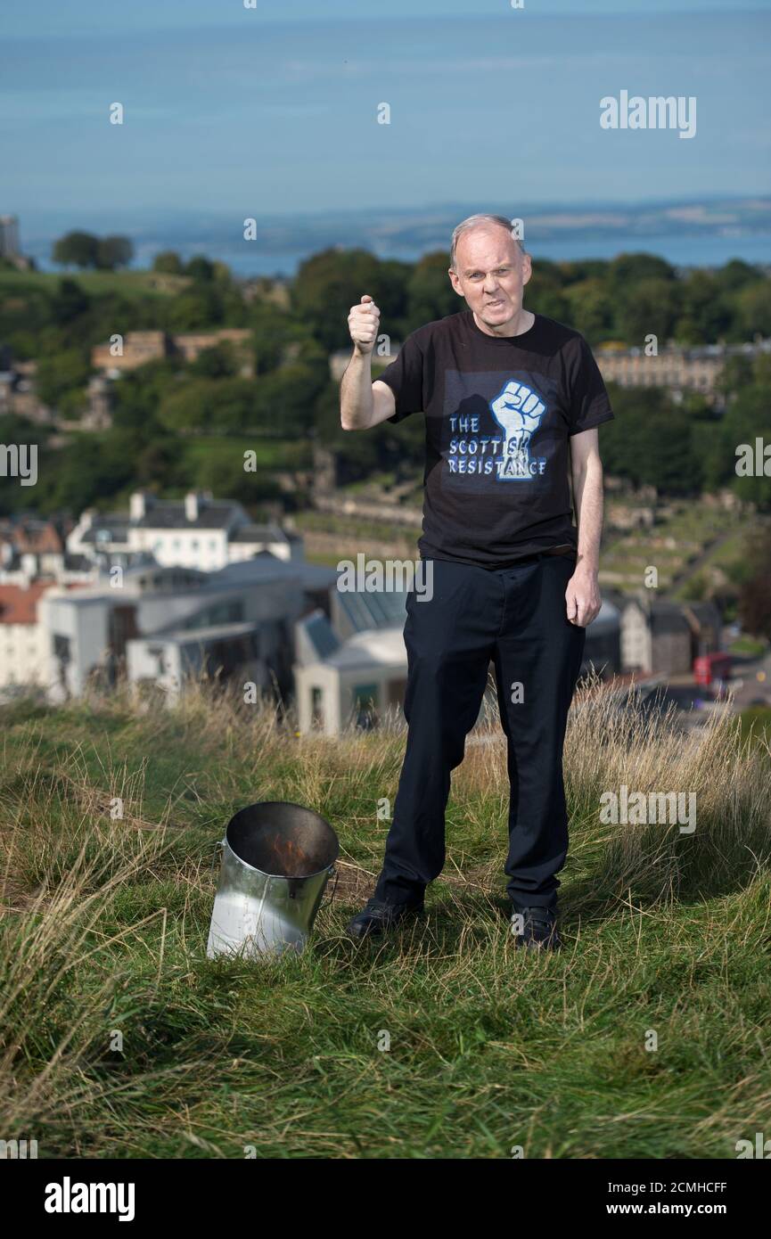 Edinburgh, Scotland, UK. 17 September 2020. Pictured: Sean Clerkin of Action For Scotland seen above the Scottish Parliament at Holyrood, Edinburgh, and burns the Union Jack Flag in a defiant act fighting for Scottish independence. Credit: Colin Fisher/Alamy Live News. Stock Photo