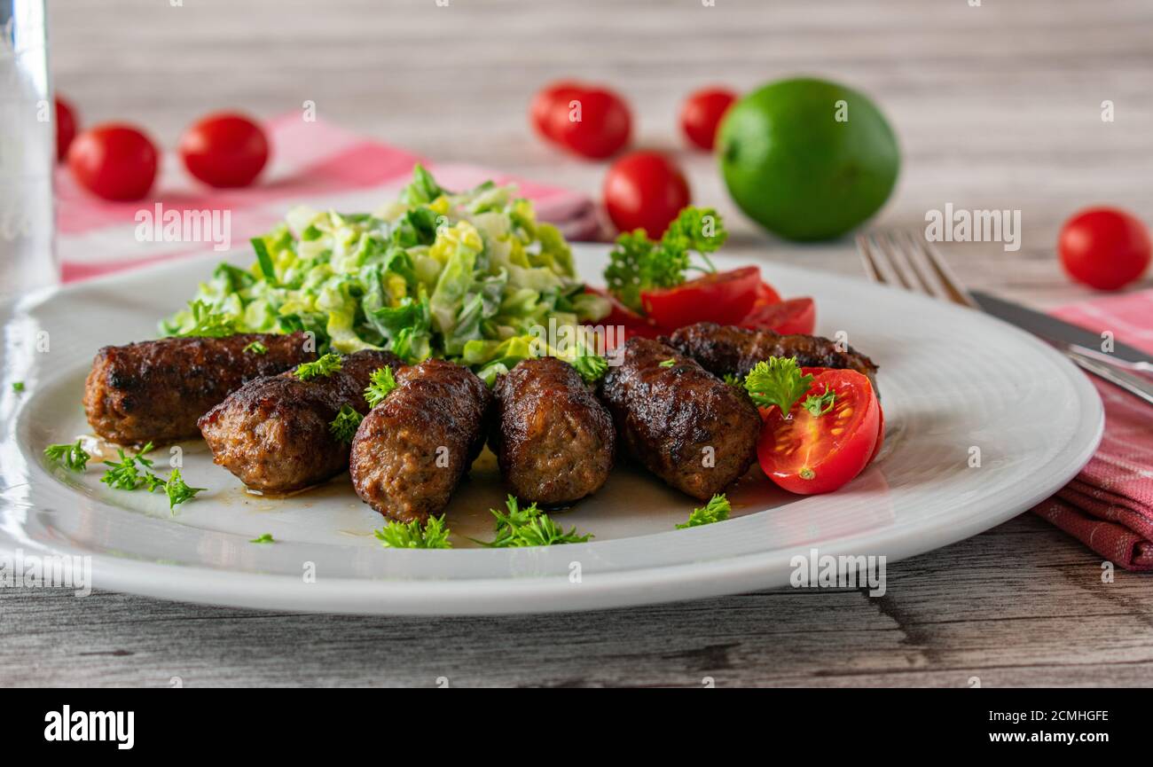 spicy minced meat rolls with salad on a plate Stock Photo