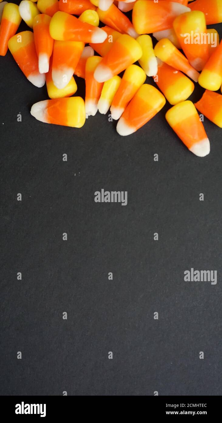 Candy corn on a black background. Halloween template with space for copy. Stock Photo