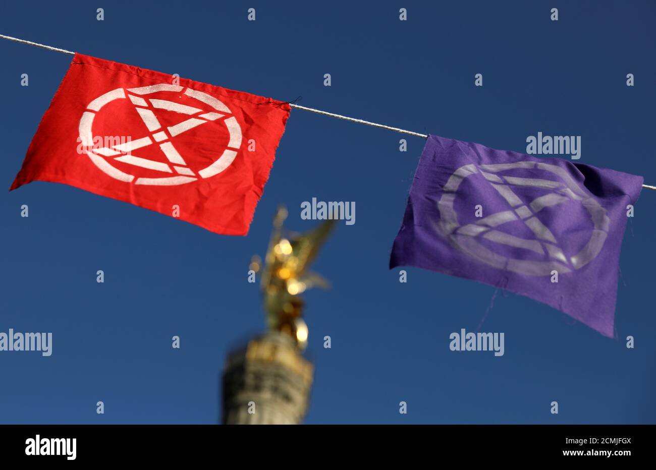 Flags with the extinction symbol flutter in front of the Victory Column during the Extinction Rebellion protest near Brandenburg Gate in Berlin, Germany, October 7, 2019. REUTERS/Christian Mang Stock Photo