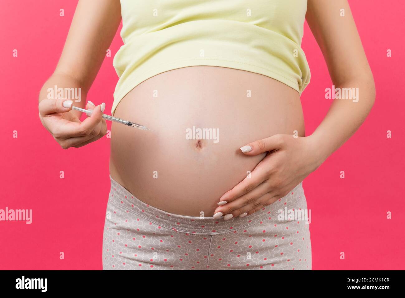 Close up of pregnant woman making injection of insulin in her belly at