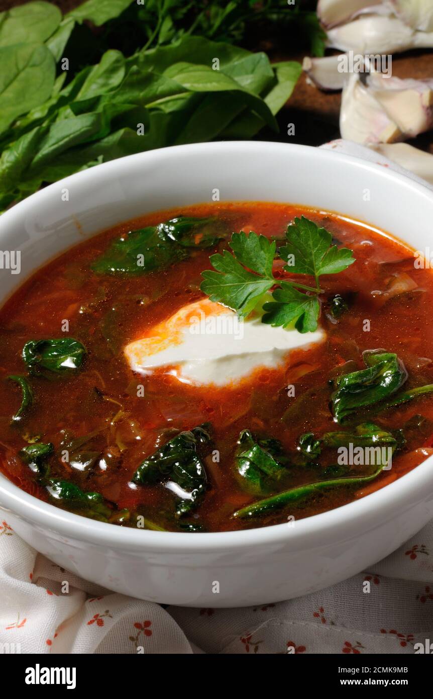 Vegetable bowl, tomato soup with spinach and sour cream. Vertical shot. Stock Photo