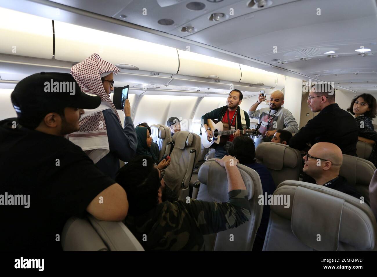 Saudi youth plays musical instrument on board a plane during a flight