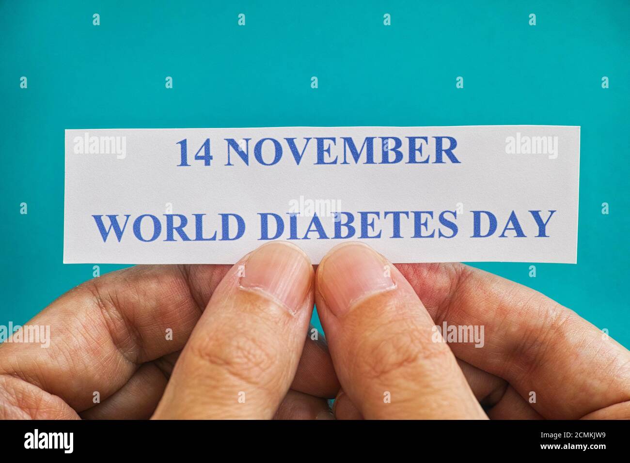 Person holding piece of paper with the words World Diabetes Day (14 November). Close up. Stock Photo