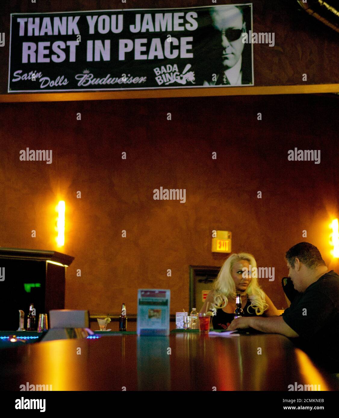 An employee and a customer talk at the bar under a sign at Satin Dolls,  which stood in as the Bada Bing Club filmed in the TV show "The Sopranos",  in Lodi,