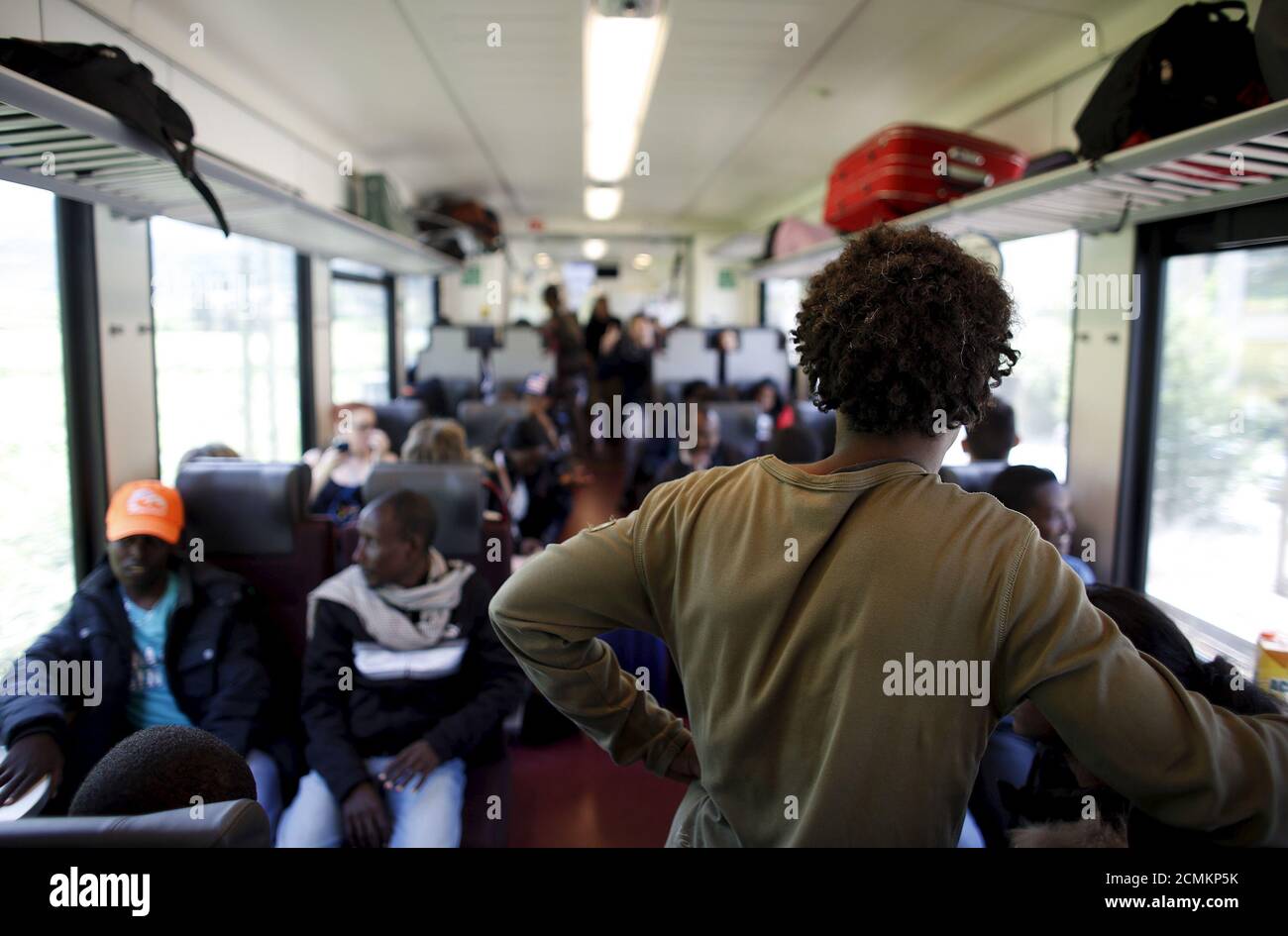 Migrants travel on a train from Bolzano to Brenner, northern Italy, May 28, 2015. EU asylum rules, known as the Dublin Regulation, were first drafted in the early 1990s and require people seeking refuge to do so in the European country where they first set foot. Northern European countries defend the policy as a way to prevent multiple applications across the continent. Some are upset with what they see as Italy's lax attitude to registering asylum seekers. Earlier this year, French police stopped about 1,000 migrants near the border and returned them to Italy. Smaller round-ups happen daily i Stock Photo