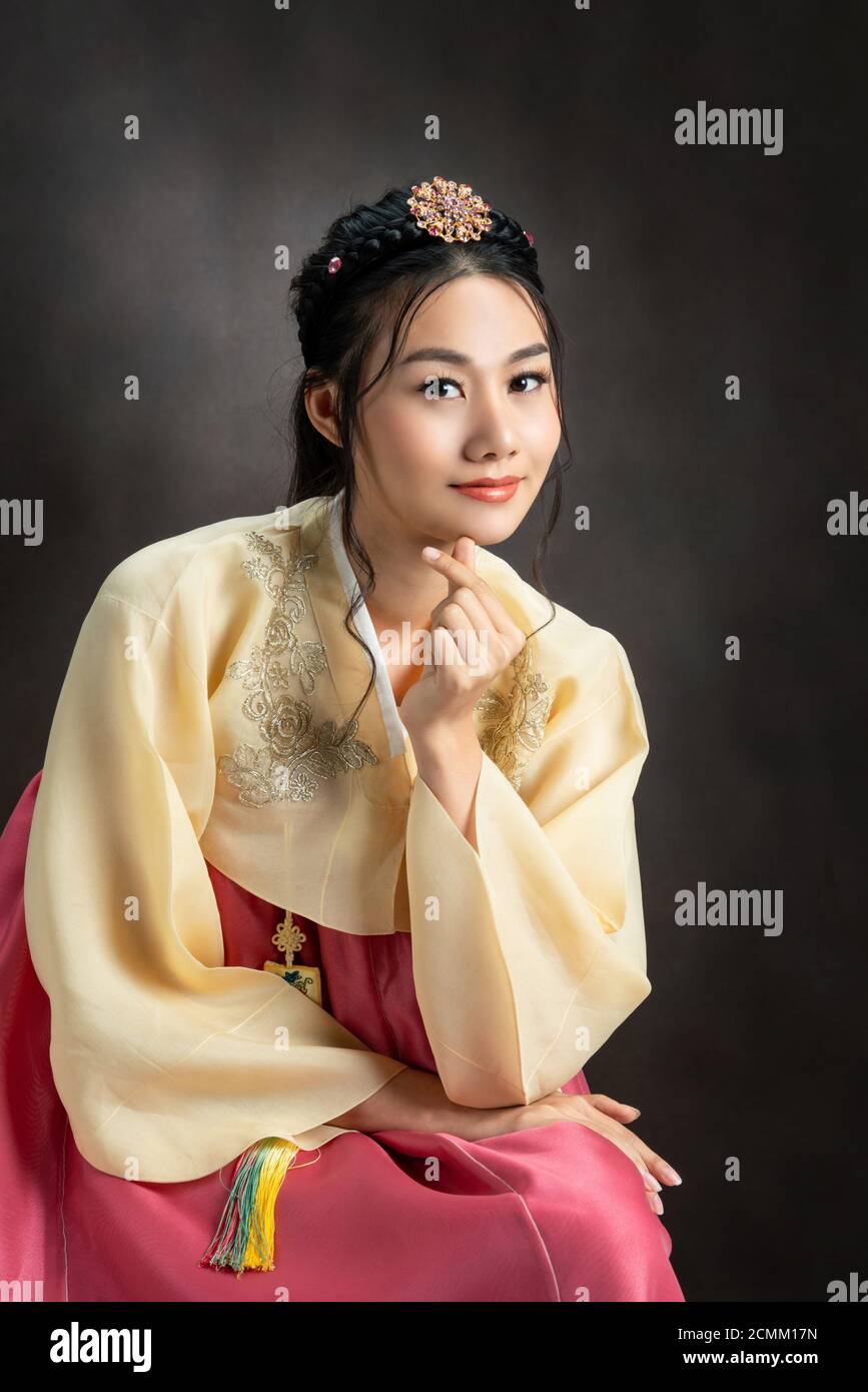 Korean woman wearing traditional korean dress (Hanbok) on black background in studio. Beautiful