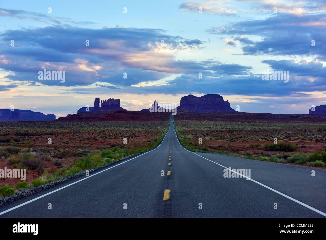 Monument Valley Arizona / Utah desert landscape with vanishing perspective of highway into distant landscape. Stock Photo