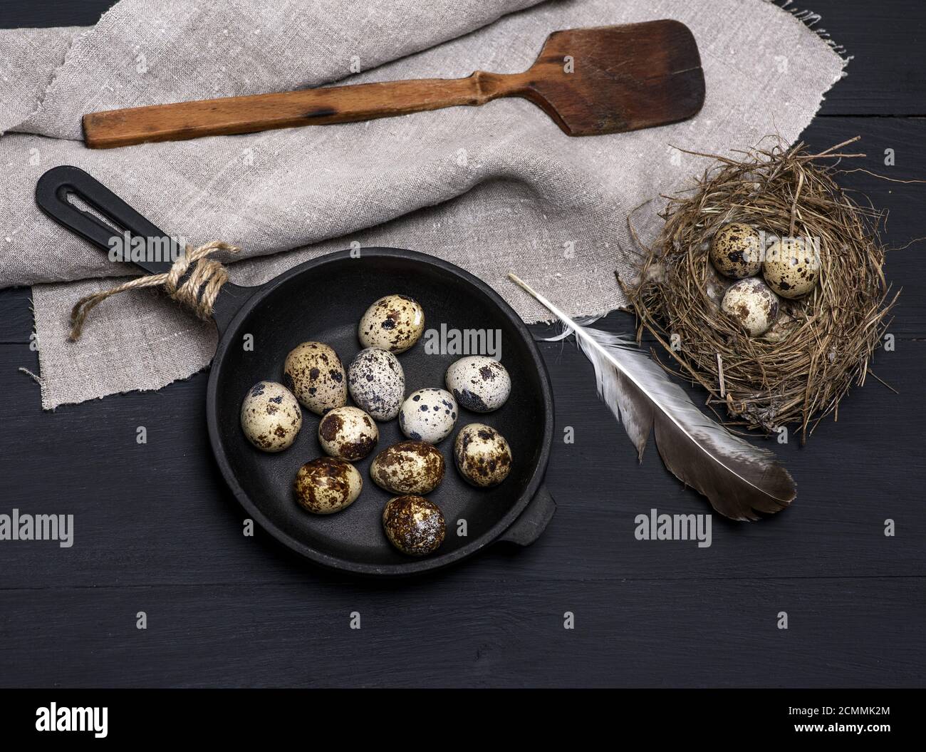 raw quail eggs in the shell lie in a black castiron frying pan Stock