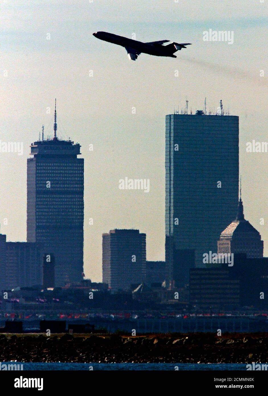 A United Airlines jetliner passes Boston's Prudential (L) and John Hancock (R) towers as it takes off from Logan International Airport October 11, 2001. Massport, the state agency which runs the airport, announced a projected $51-million budget shortfall and up to 180 layoffs exactly one month after two United and American airlines planes out of Logan were hijacked and crashed into the World Trade Center Towers. REUTERS/Jim Bourg  JRB Stock Photo