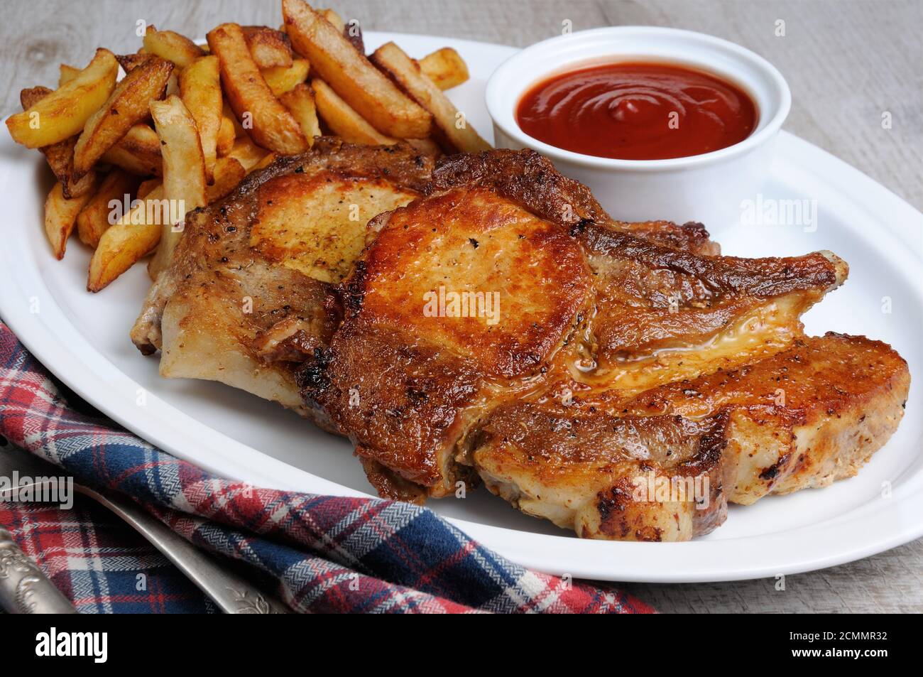 Fried pork loin steak with French fries and tomato sauce Stock Photo