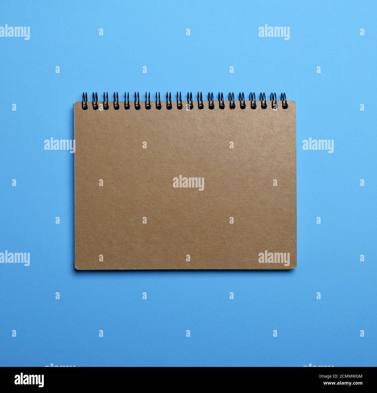 notebook on a black iron spring with brown empty sheets Stock Photo