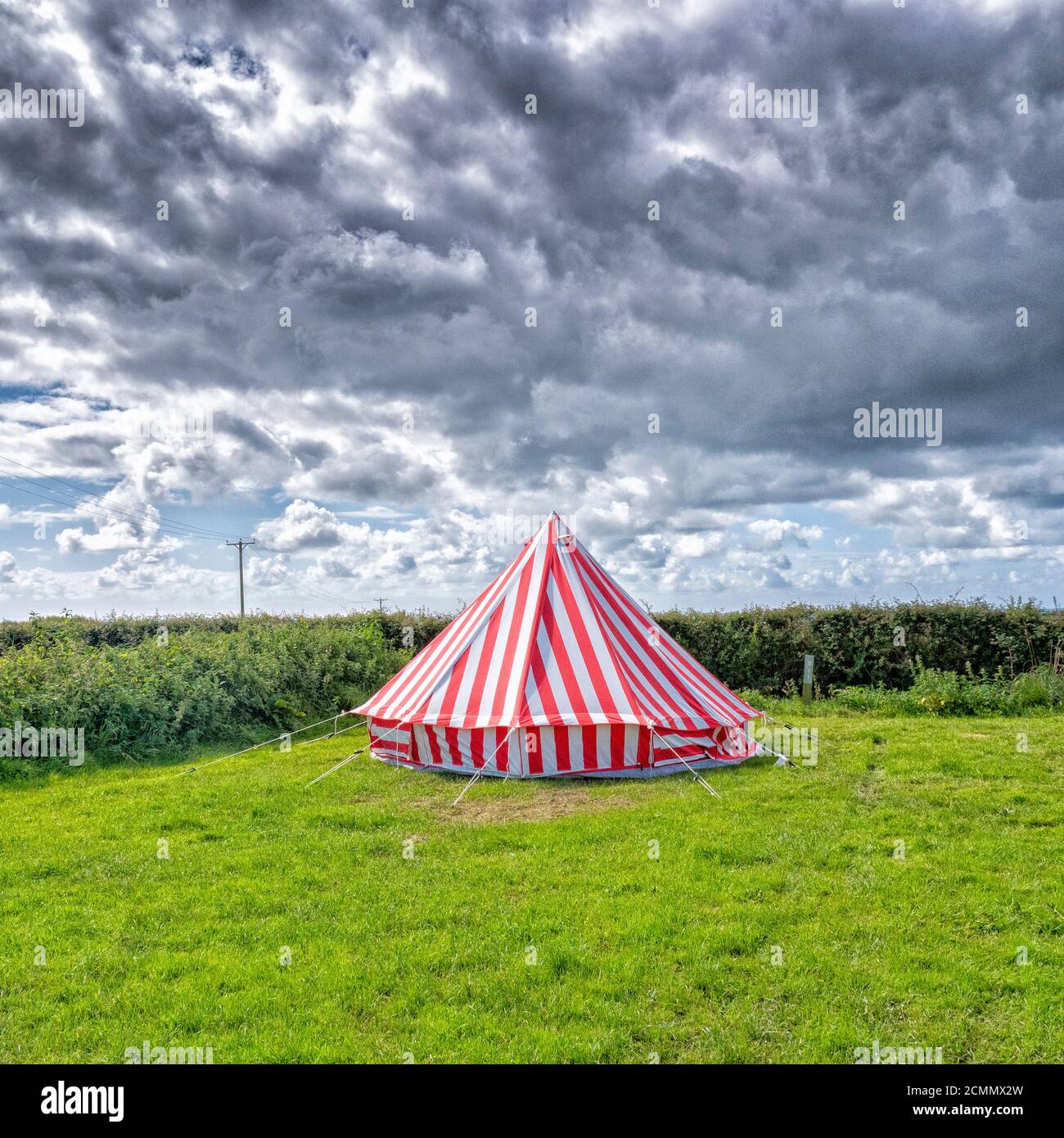 A brightly coloured red and white striped tent in a a campsite in the UK Stock Photo