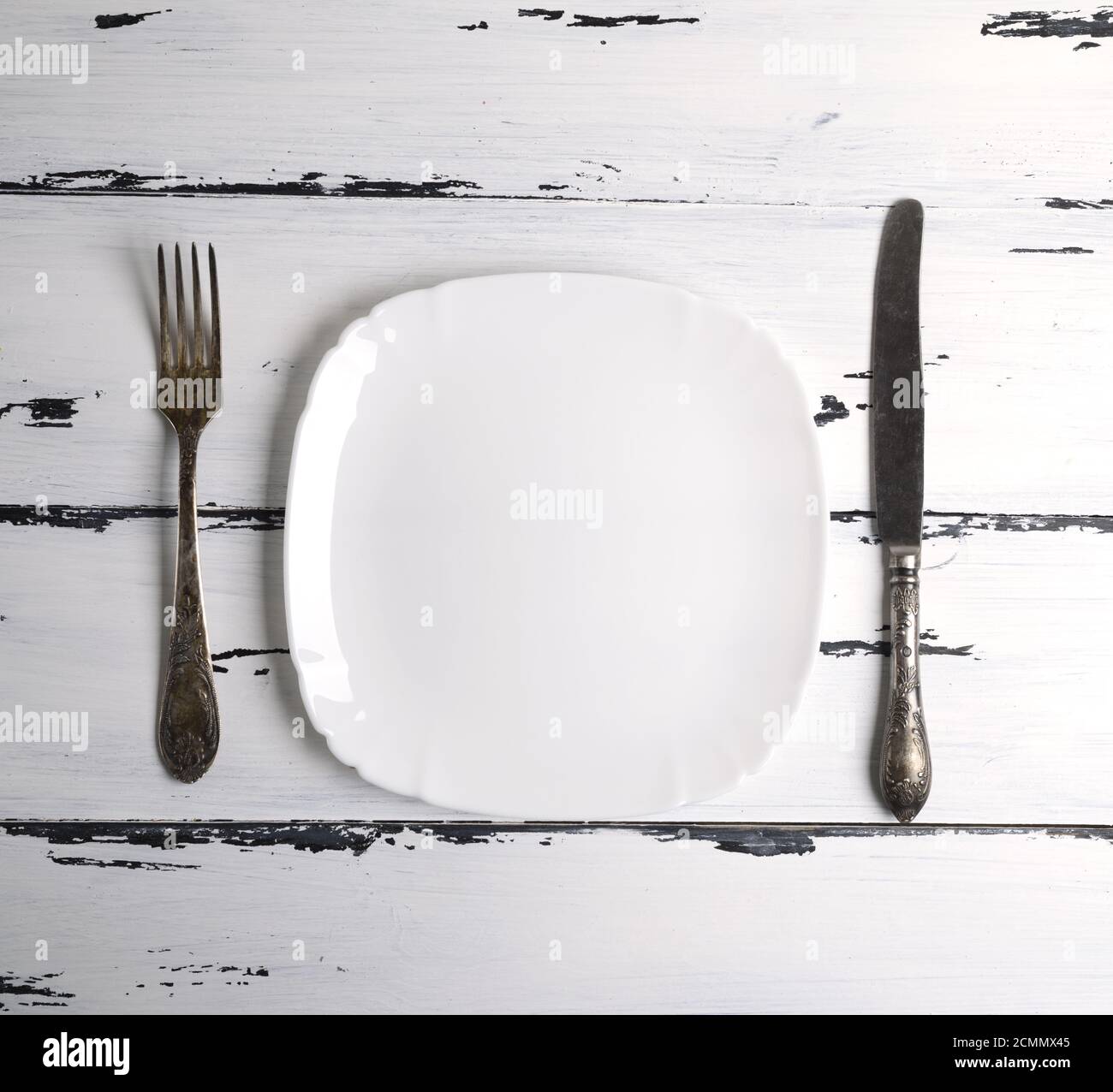 empty white ceramic plate with a fork and knife Stock Photo