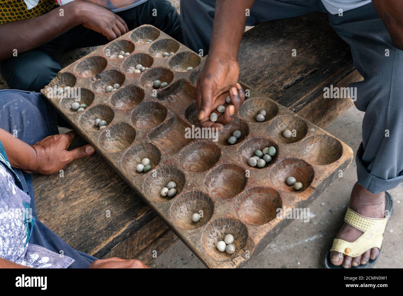 Hands of Black African People playing Mancala game, Dar Es Salaam, Tanzania. Mancala or Bao is a game which is very popular in Africa and Arabs Stock Photo