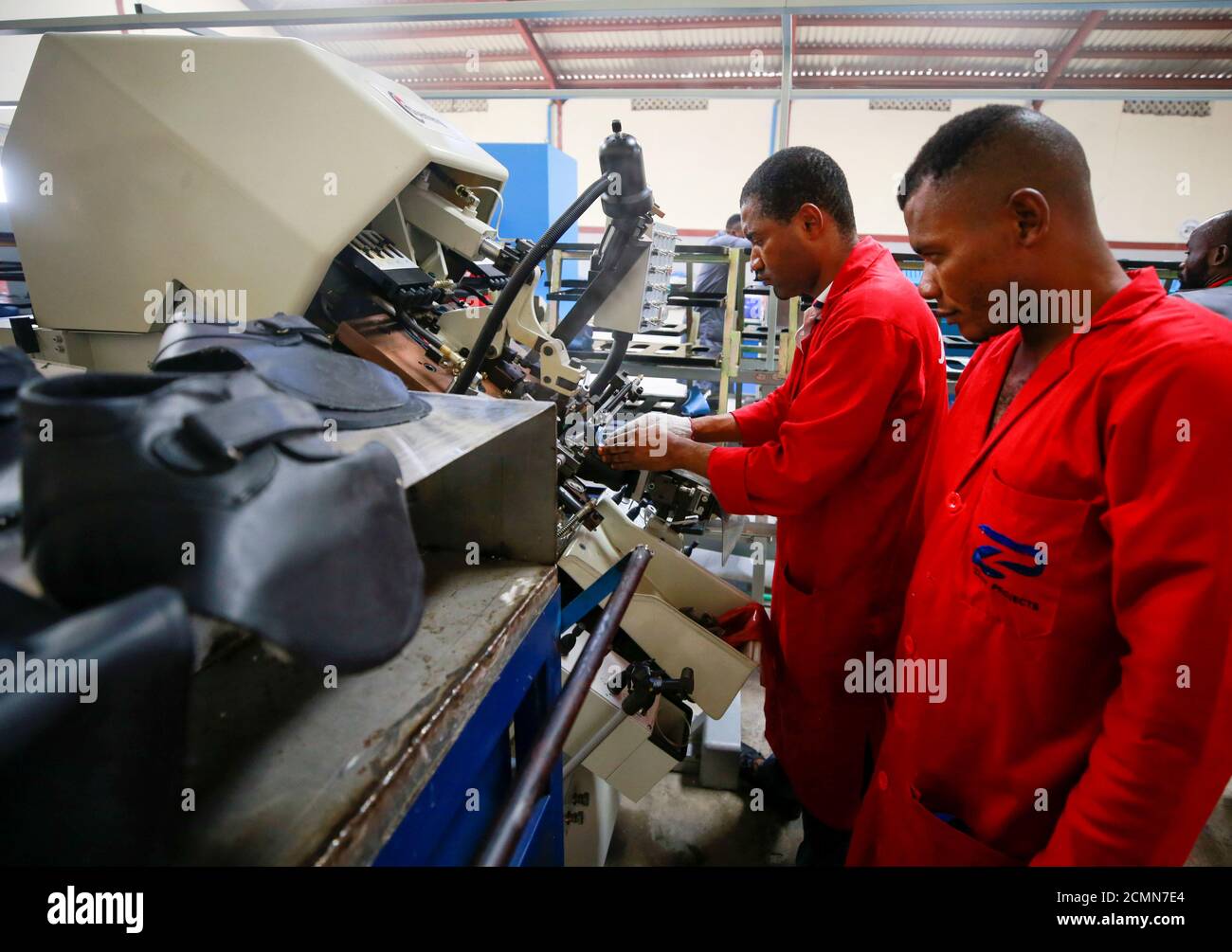 Workers operate a machine at a Bata shoe factory in Abuja, Nigeria January 13, 2020. Picture taken January 13, 2020. REUTERS/Afolabi Sotunde Stock Photo