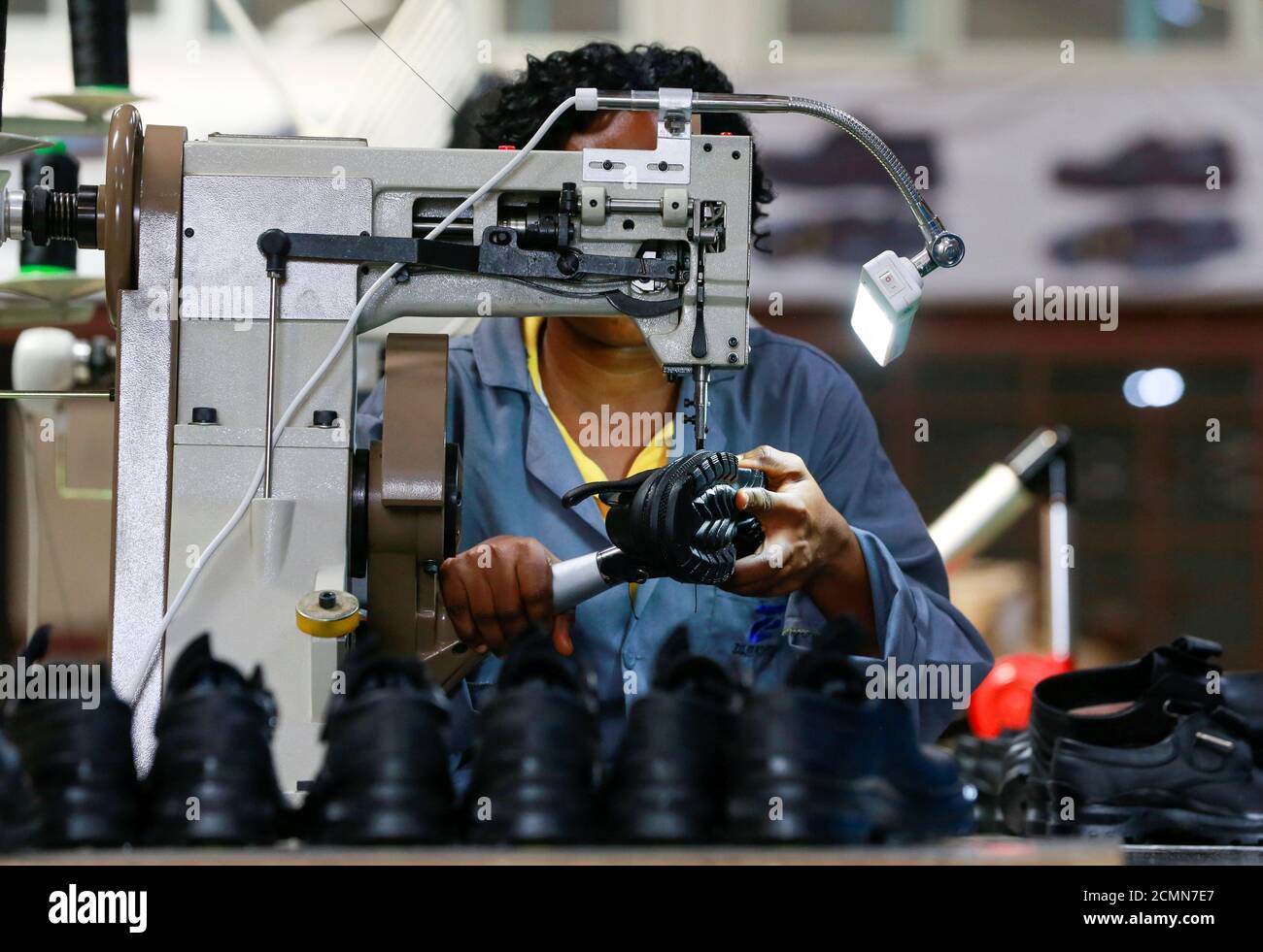 An employee works on a shoe inside a Bata shoe factory in Abuja, Nigeria January 13, 2020. Picture taken January 13, 2020. REUTERS/Afolabi Sotunde Stock Photo