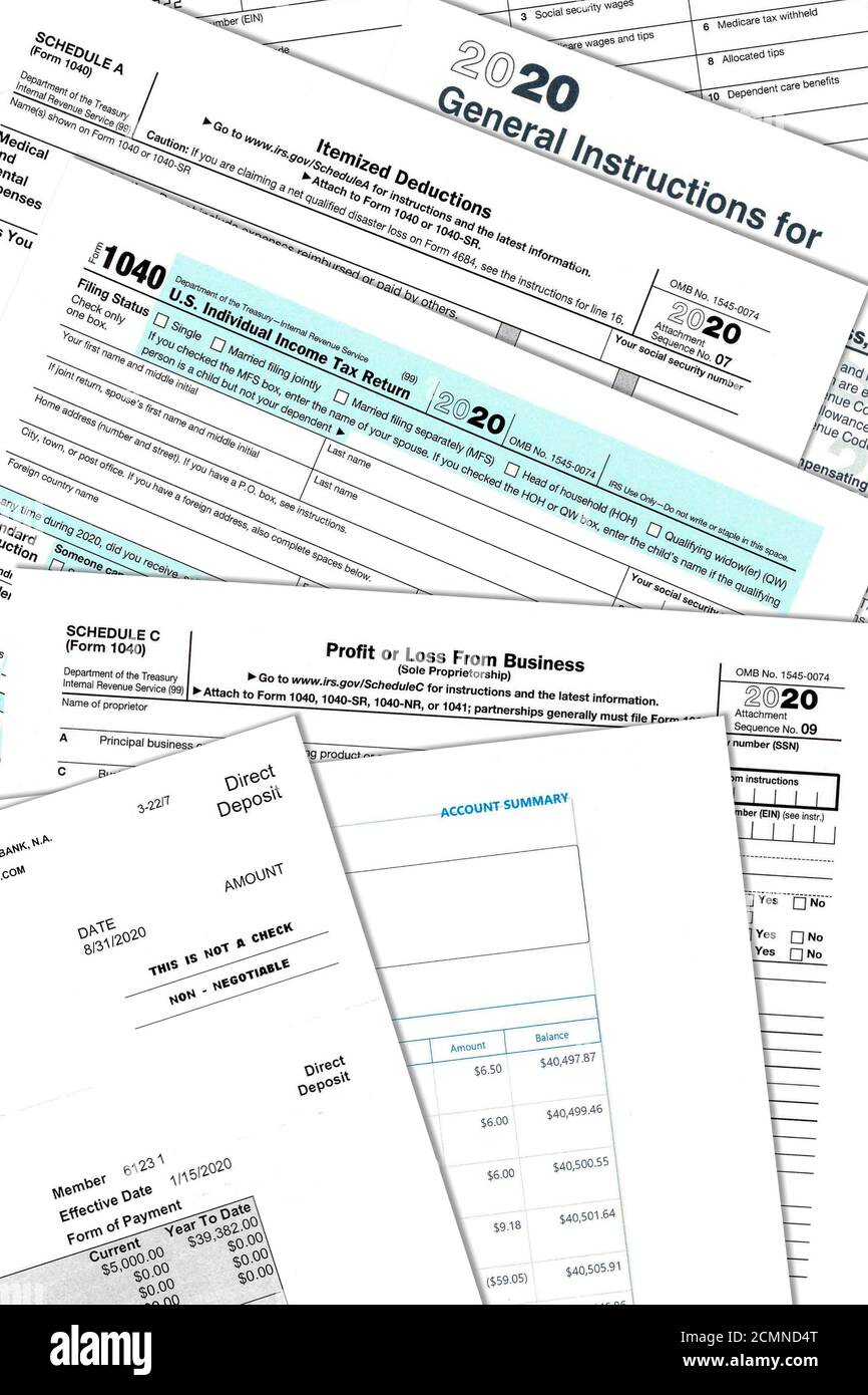 2020 IRS tax forms and personal papers on a desktop. Stock Photo