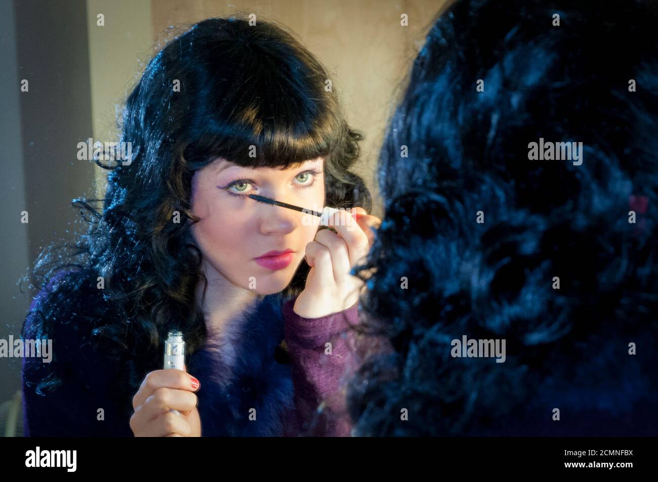 Young woman applying mascara. Getting ready for the play. Heritage Park Secondary School, Mission, BC, Canada Stock Photo