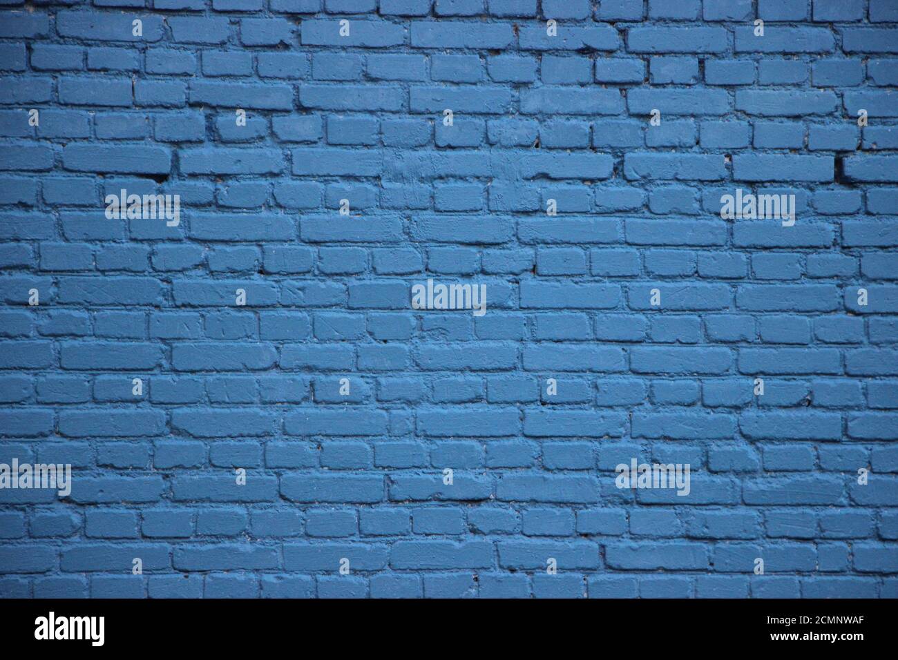 Old brick wall painted into solid blue Stock Photo