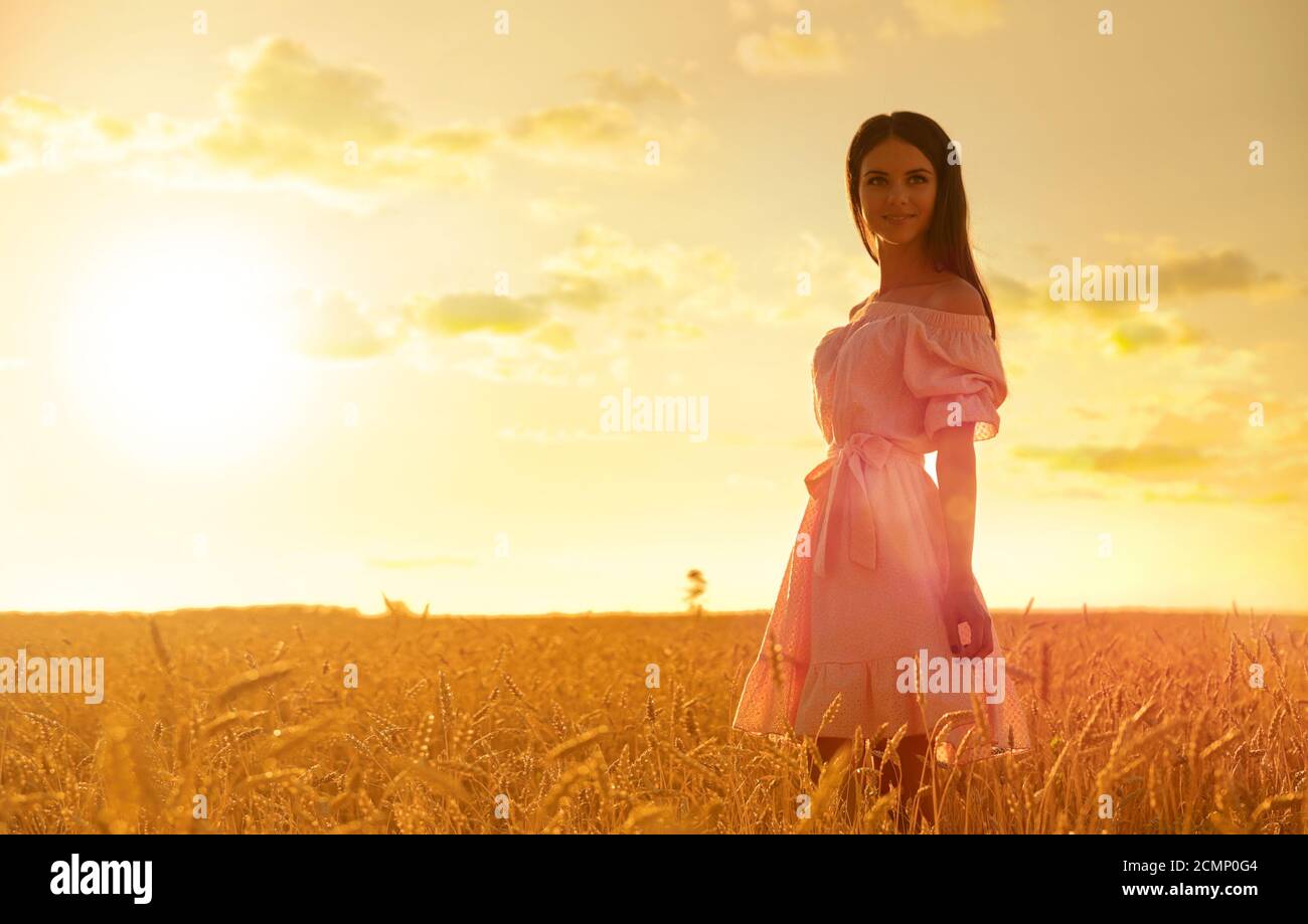 Young girl in wheat field at sunset Stock Photo - Alamy