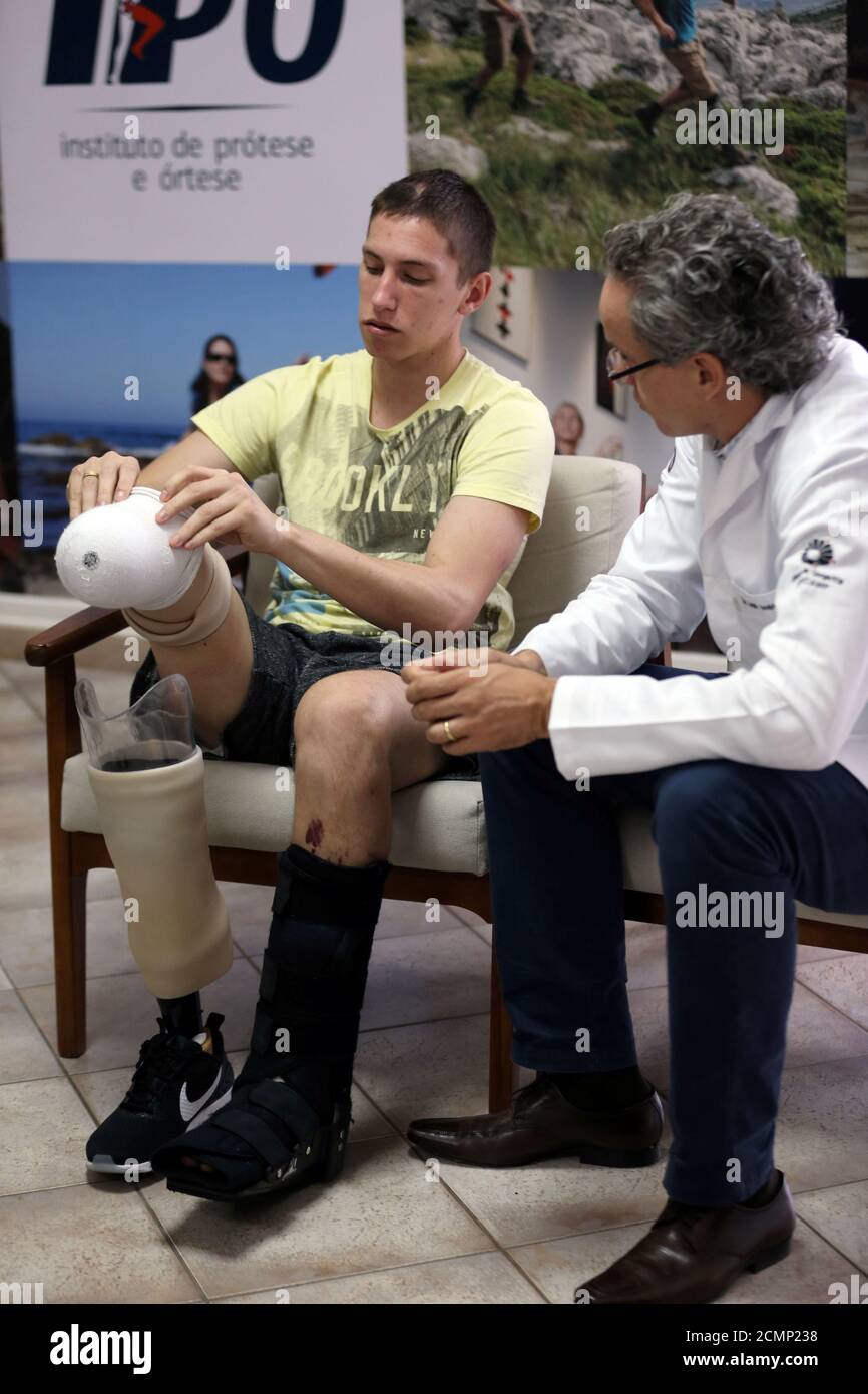 Goalkeeper Jackson Follmann (L), who survived when the plane carrying Brazilian soccer team Chapecoense crashed, talks with Dr. Jose Carvalho as they try on a prosthetic leg in Sao Paulo, Brazil, February 21, 2017. REUTERS/Paulo Whitaker Stock Photo