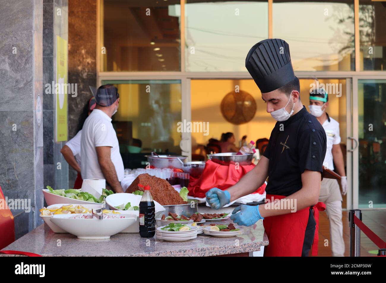 Turkish chef in a face mask prepares a dish to be served in the hotel's restaurant. Safety measures for tourists during the covid-19 coronavirus Stock Photo