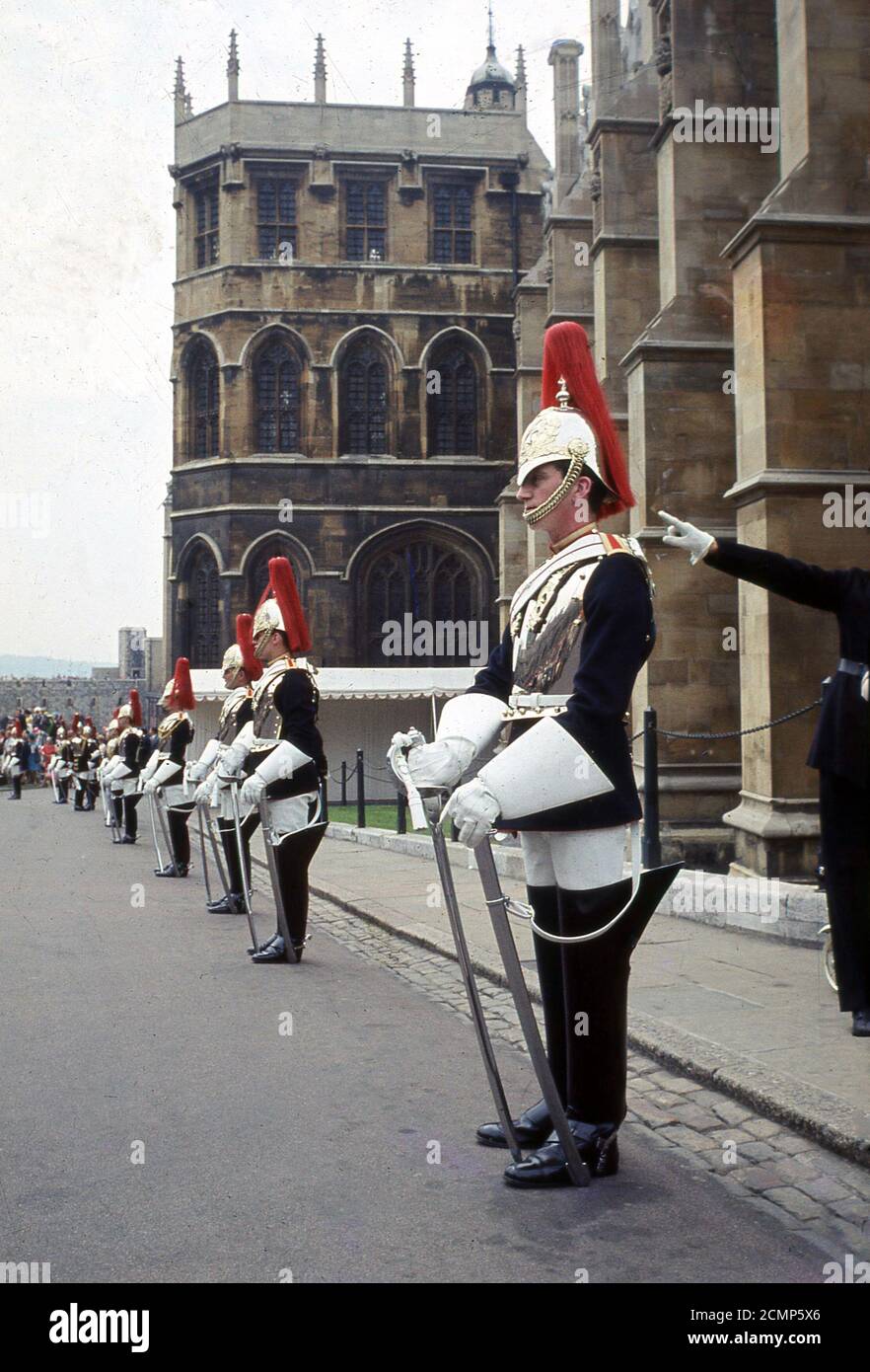 1960s, historical, Windsor Castle, a line-up of Queens Guards on ceremonial duty. Since 1660, the priviledge of guarding the Sovereign has belonged to the Household Troops or 'the Guards', which consists of five infantry regiments - The Grenadier, Coldsteam, Scots, Irish and Welsh Guards - and two regiments of the Household Cavalry - the Life Giards and the Blues and Royals. Stock Photo