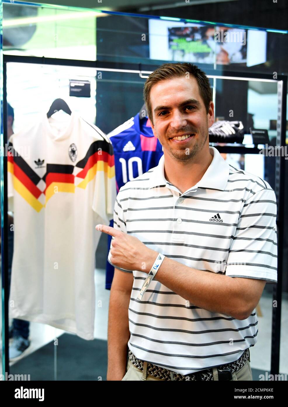 Former German soccer player Philipp Lahm points at a 1990 Germany jersey as  he attends the celebrations for German sports apparel maker Adidas' 70th  anniversary at the company's history exhibition in Herzogenaurach,