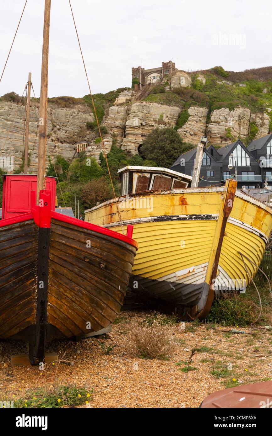 Fishing boats on Hastings beach with a view toward The East Hill lift built on cliffs which
