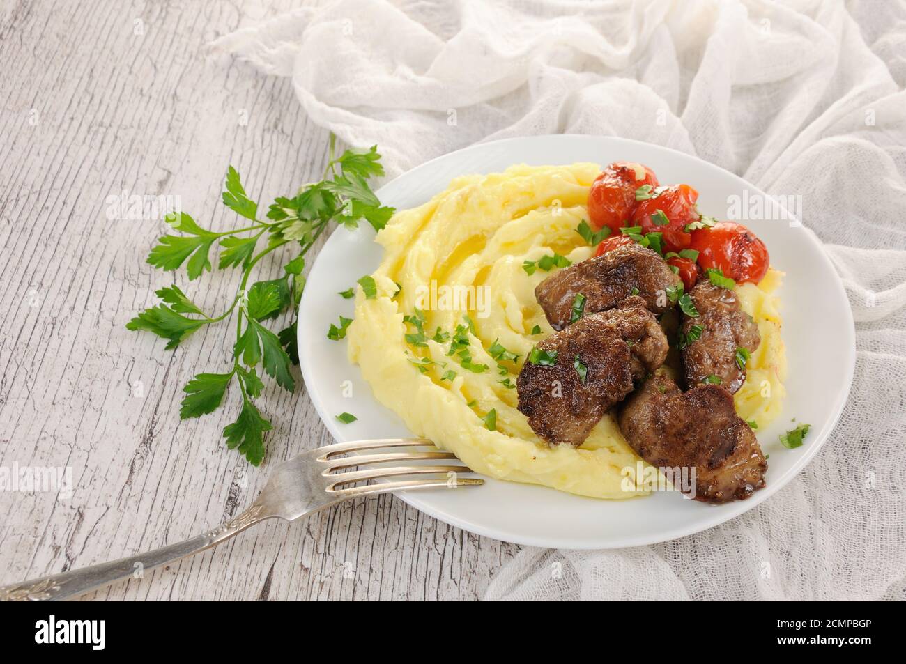 Fried chicken liver with vegetable garnish of mashed potatoes and baked