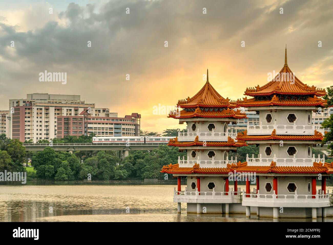 The Twin Pagodas at the Chinese Garden in contrast to modern train and modern HDB buildings in the heartlands of Singapore Stock Photo