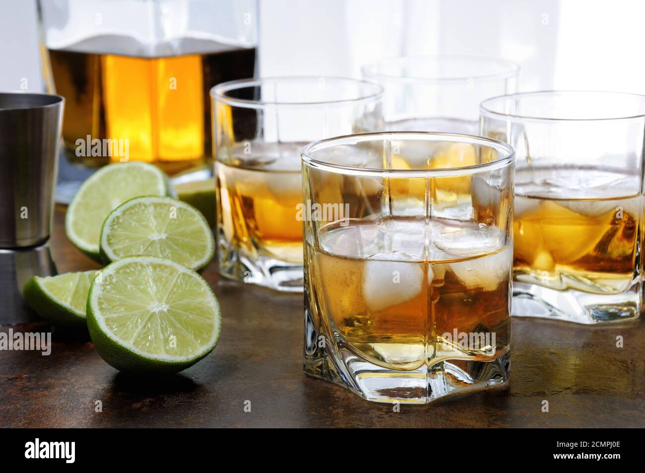 Alcohol cocktail with brandy, whiskey or rum with Ginger Ale, lime and ice in glasses Stock Photo