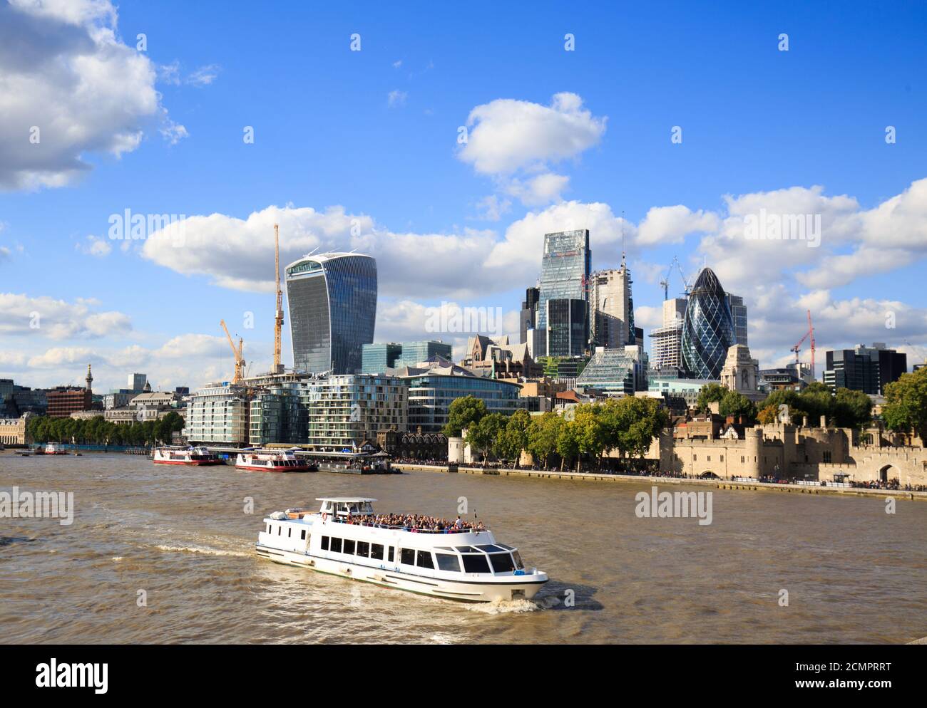 Boat Trips on the River Thames are a popular way of seeing the sights of London.  Tourists taking a trip up the River enjoying the iconic buildings al Stock Photo