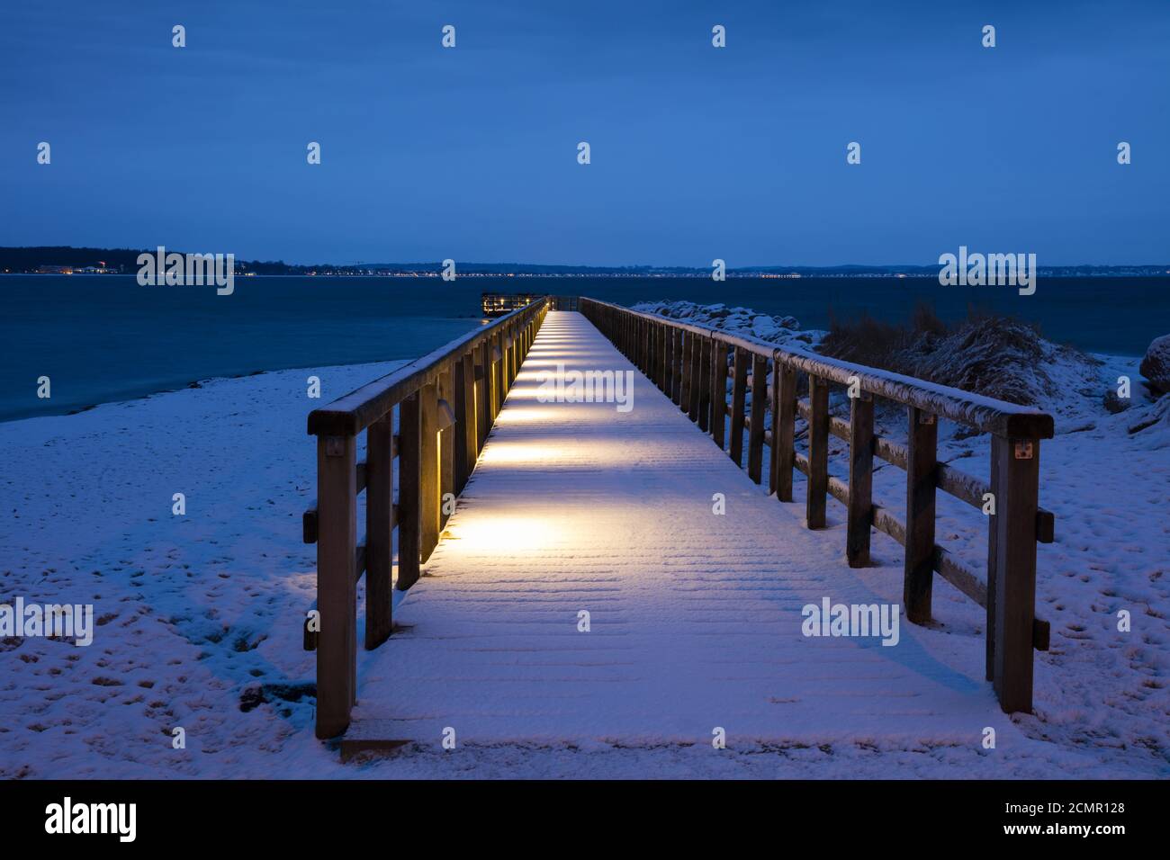 Illuminated pier with snow, Niendorf, Baltic Sea Stock Photo