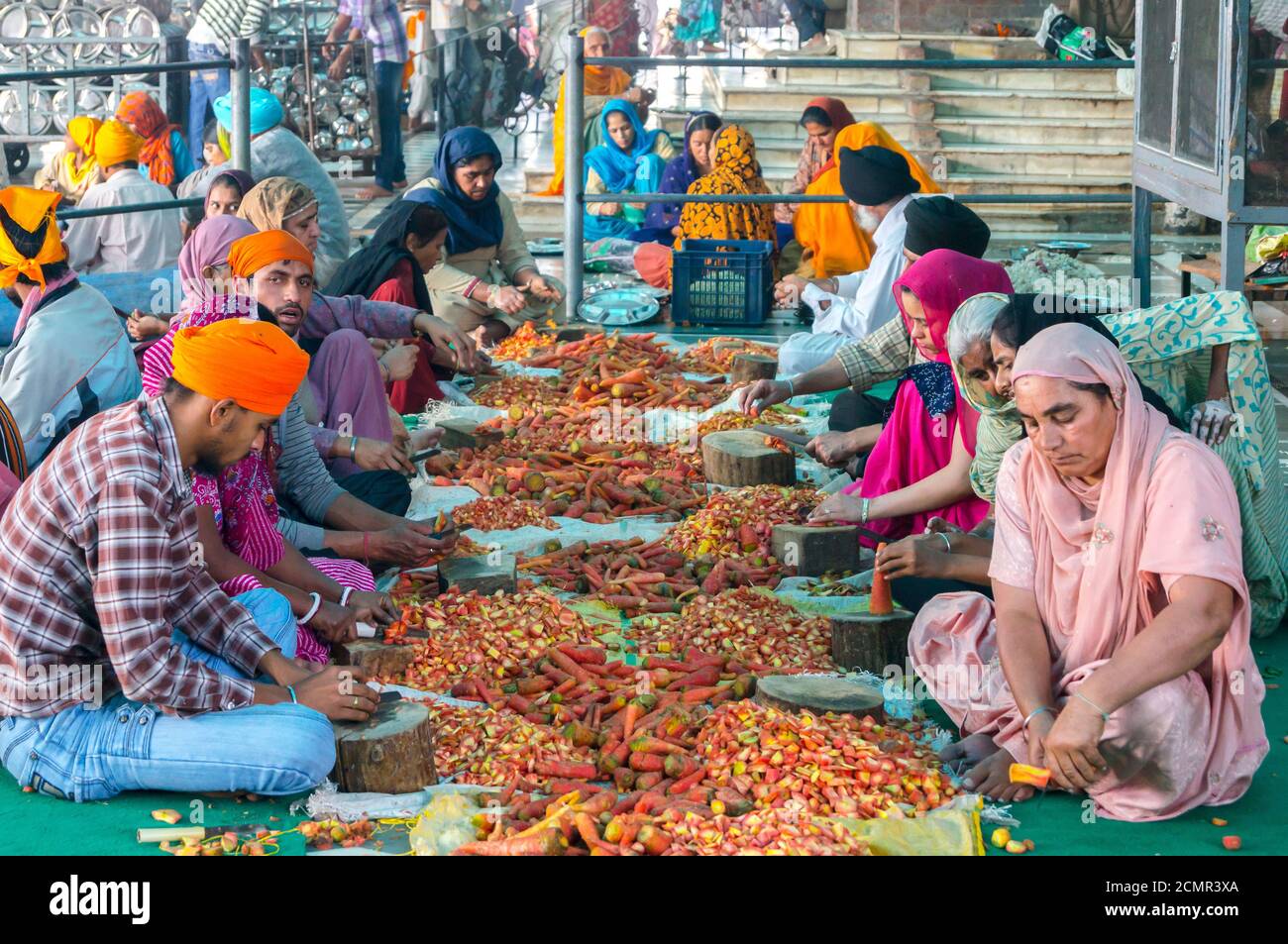 Amritsar, India - November 21, 2011: Unknown Indian people peel vegetables for a free meal for pilgrims. Golden Temple in Amritsar, Punjab, India. Stock Photo