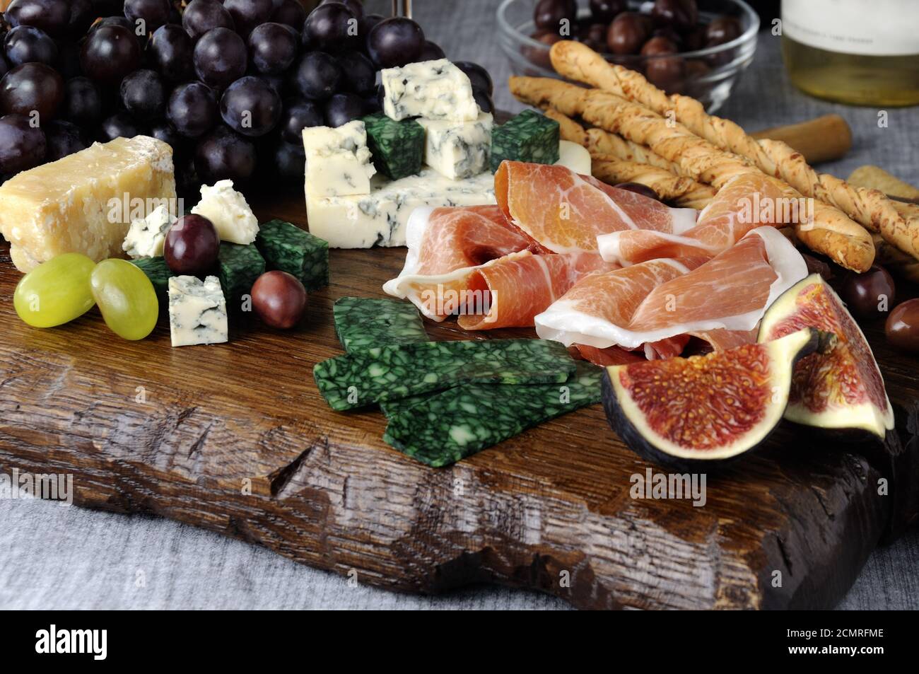 Dishes for Antipasto on a wooden board with prosciutto, different types