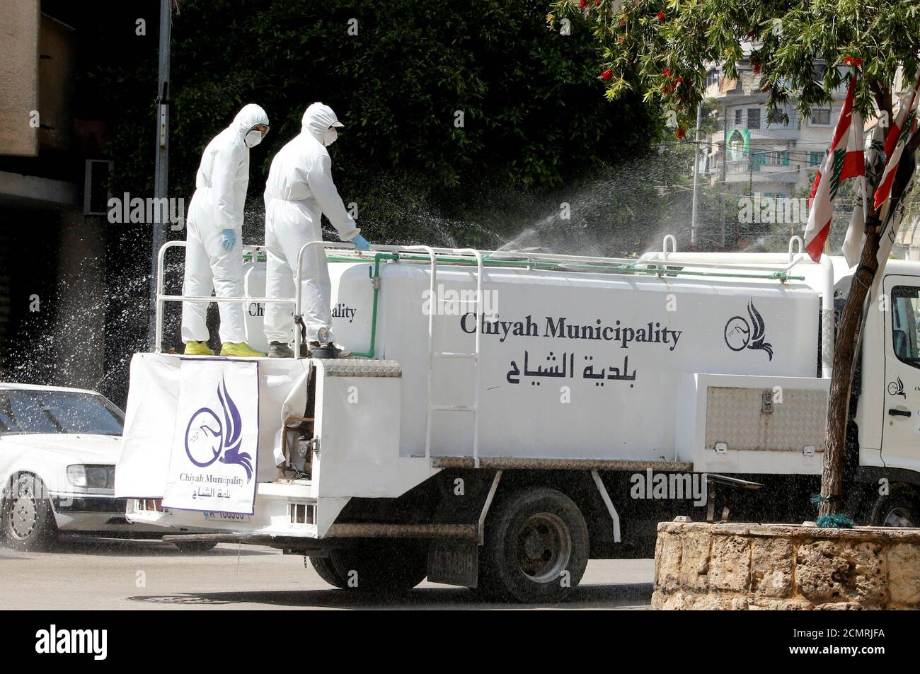Workers of the municipality sanitize a street, as Lebanon is set to extend a countrywide lockdown by two weeks to combat the spread of coronavirus disease (COVID-19) in Ain el-Remmaneh, Lebanon March 26, 2020. REUTERS/Mohamed Azakir Stock Photo