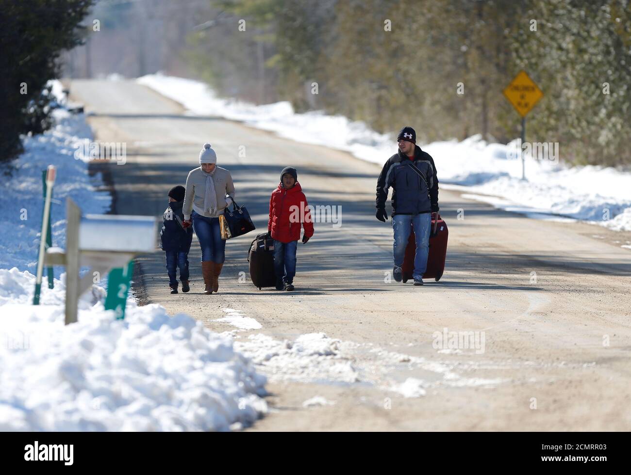 A family that says they are from Colombia walks down Roxham Road toward