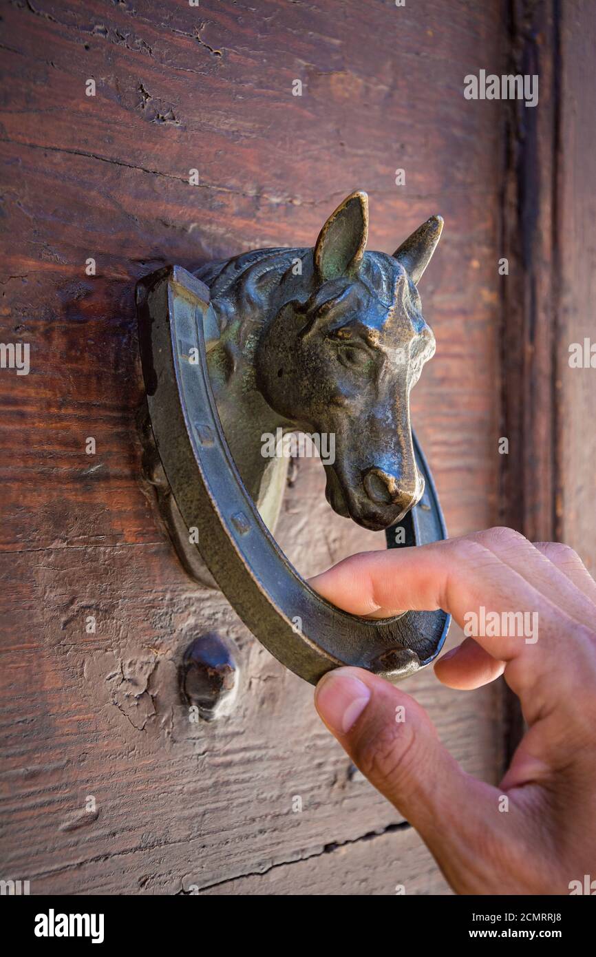 Guest Knocking Wooden Traditional Door, in front of the House Stock Photo