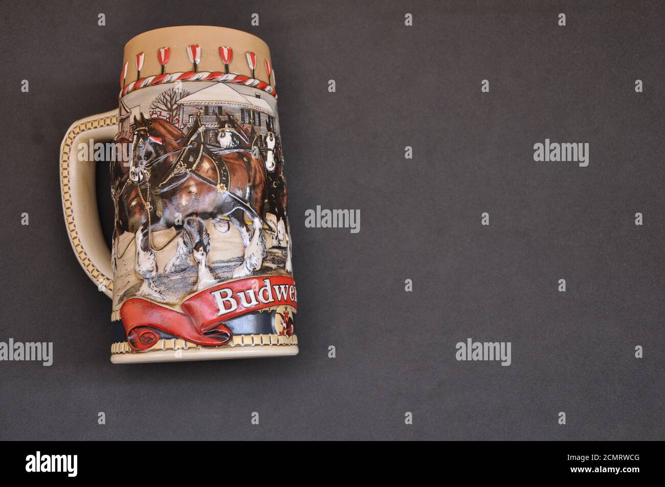 Ceramic mug, with high relief logo of the Budweiser beer, with horses, on a black background, used to drink beer Stock Photo