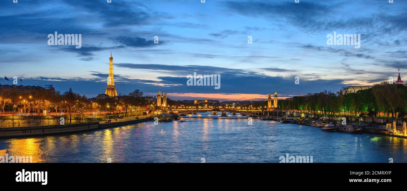 Paris France panorama city skyline night at Seine River with Pont Alexandre III bridge and Eiffel To Stock Photo