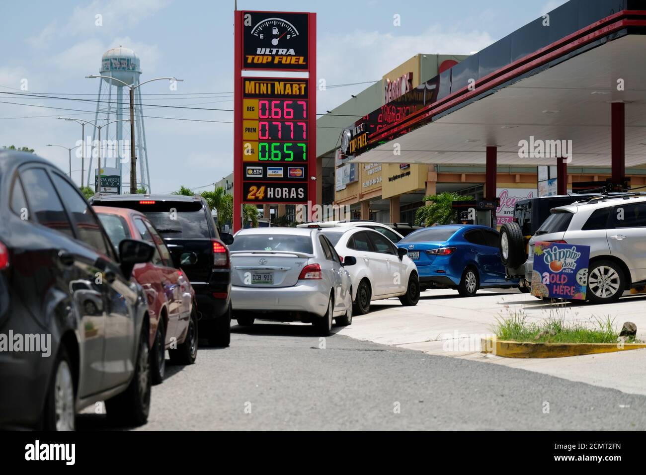 Cars line up for fuel at a gas station as Tropical Storm Dorian