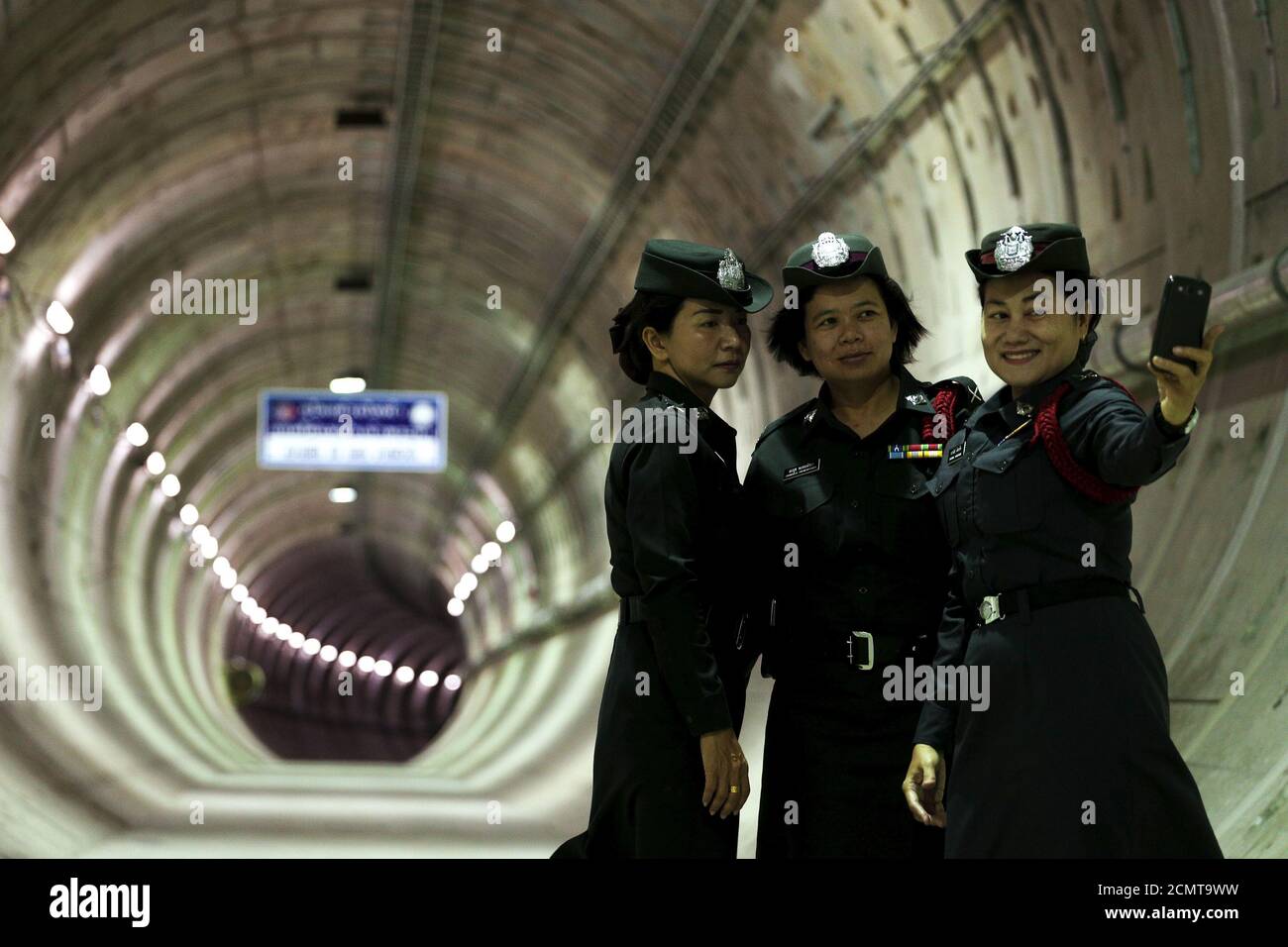 Policewomen take a picture inside a tunnel under the Chao Phraya river at a Mass Rapid Transit subway station in Bangkok, Thailand, December 14, 2015. REUTERS/Athit Perawongmetha      TPX IMAGES OF THE DAY Stock Photo