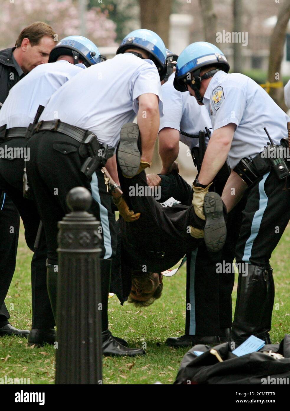 United States Park Police officers carry away an anti-war protester after arresting him for refusing to get up off the ground and leave Lafayette Park, across the street from the White House in Washington, March 26, 2003. Religious leaders and members of several peace groups came together for the non-violent civil disobedience action to protest the war in Iraq. REUTERS/Jim Bourg  JRB/GN Stock Photo