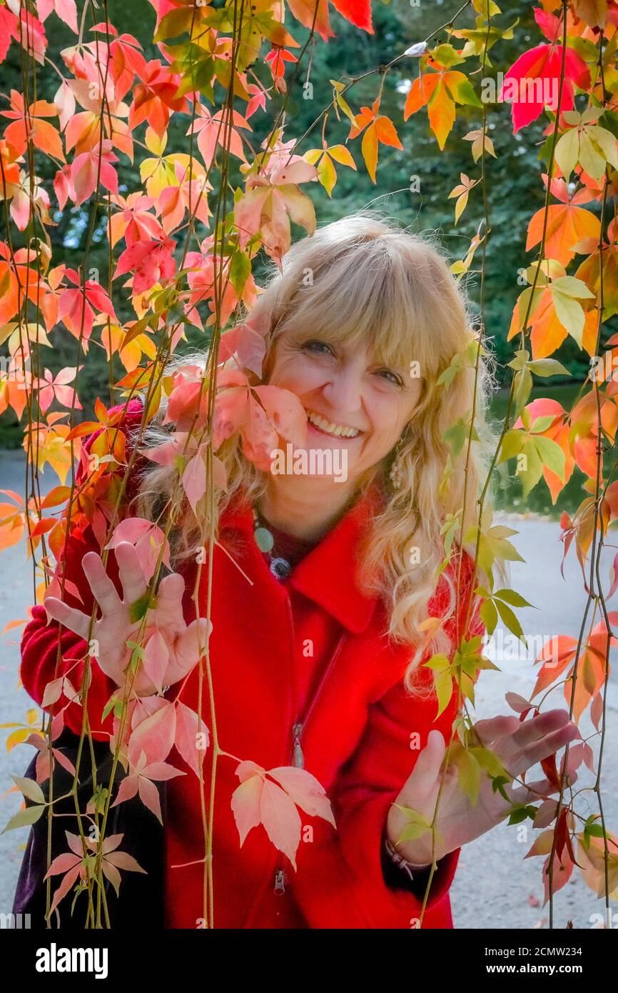 Smiling woman, autumn leaves, VanDusen Botanical Garden, Vancouver, British Columbia, Canada. Stock Photo