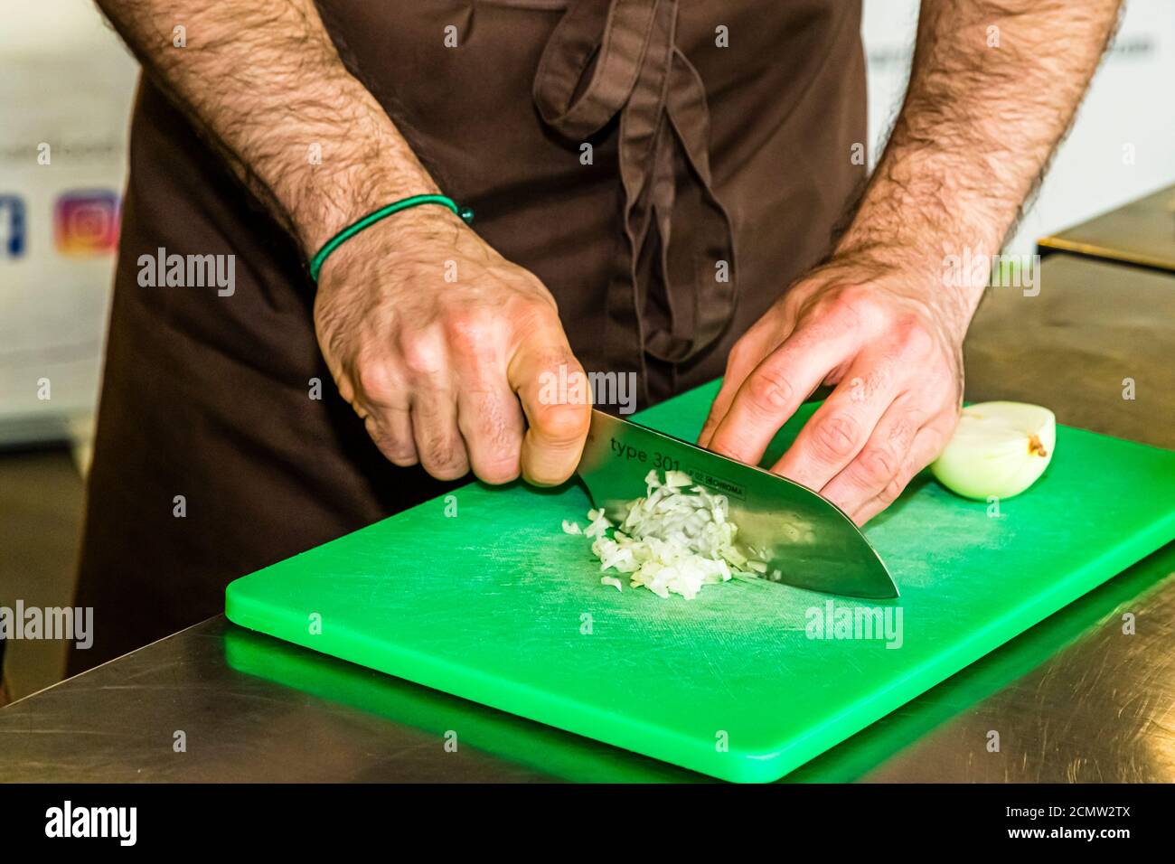Laszlo Papdi makes the chef's knife Chroma Type 301 fit for the first cutting exercise. The classic is waiting: the onion. Whether cutting an onion is tearful or tear-free depends to a large extent on the cutting technique and the sharpness of a knife Stock Photo