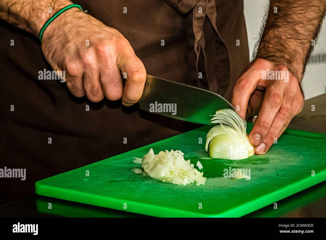 Laszlo Papdi makes the chef's knife Chroma Type 301 fit for the first cutting exercise. The classic is waiting: the onion. Whether cutting an onion is tearful or tear-free depends to a large extent on the cutting technique and the sharpness of a knife Stock Photo